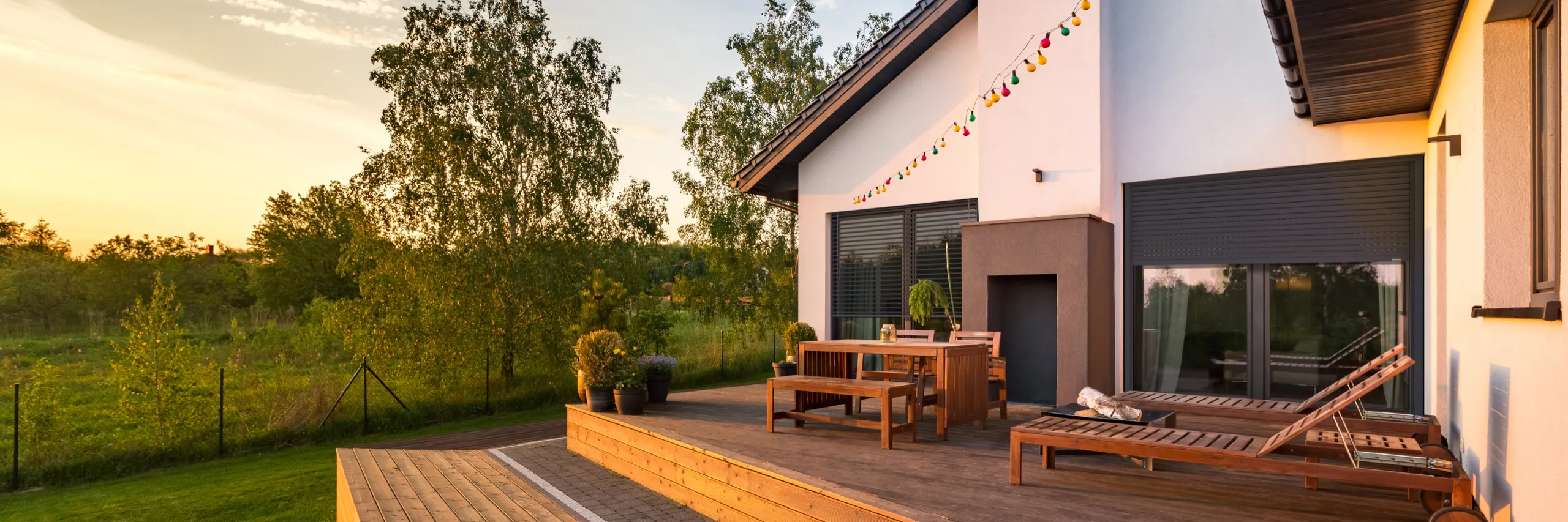 Maison avec volets roulants gris et terrasse en bois